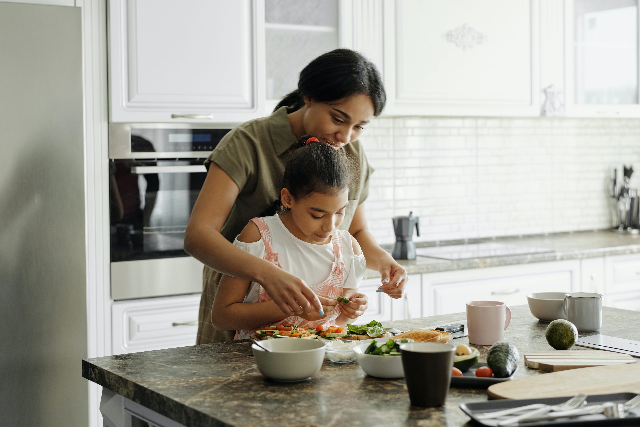 pre-diabetes-prevention-intuitive-nutrition Mother and daughter preparing avocado toast. Learn more about pre-diabetes prevention with Intuitive Nutrition.